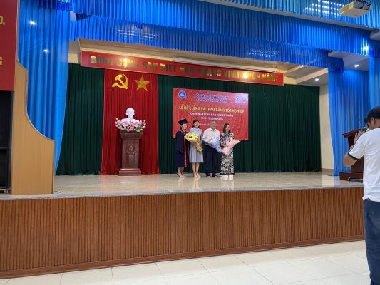 Tân cử nhân lên tặng hoa thầy cô